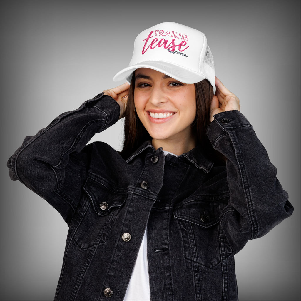 white with pink lettering trailer tease hat. 