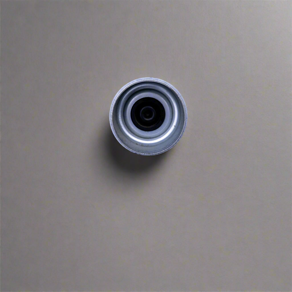 Metallic cylindrical object on a beige textured surface